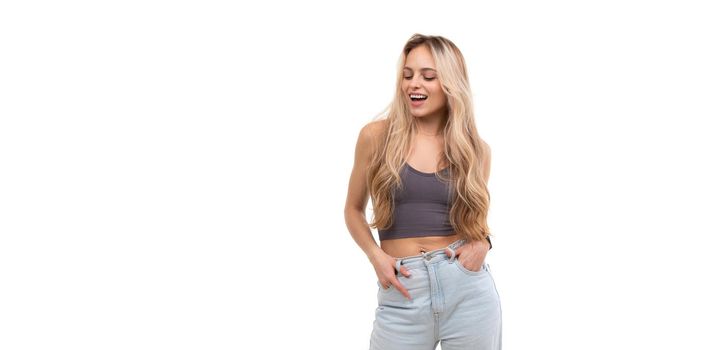 beautiful young woman in gray tank top laughing over isolated background.