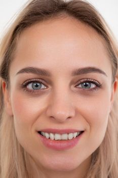 close-up portrait of a beautiful blonde with straight white teeth.