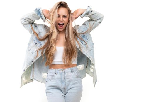 young charismatic blonde in a blue denim suit fooling around on the background with a smile looking at the camera.