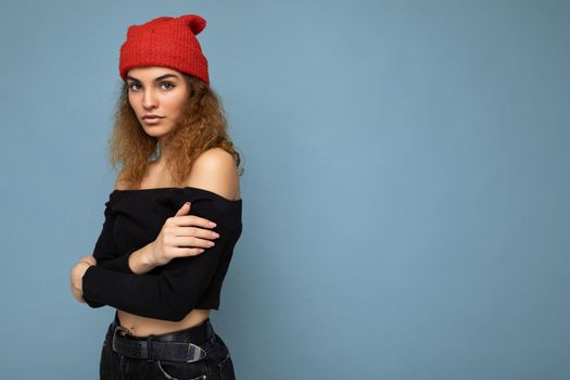 Side-profile photo of pretty serious young dark blonde woman standing isolated over colourful background wall wearing everyday trendy clothes looking at camera. Empty space