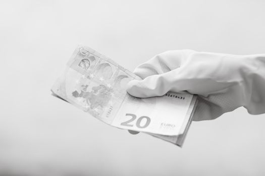 Hand with gloves receiving, giving or holding USD EURO banknote. World money concept