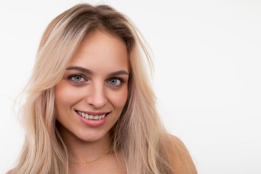 charming middle-aged blonde with a smile on her face looking at the camera on a white background.