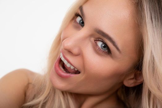 half-turn portrait of young woman smiling with teeth look at the camera.