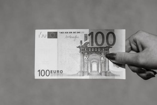 Hand holding and showing euro money or giving money. World money concept, 100 EURO banknotes EUR currency isolated. Concept of rich business people, saving or spending money.