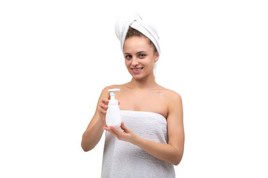 middle-aged woman holding a bottle of white soap in her hands.