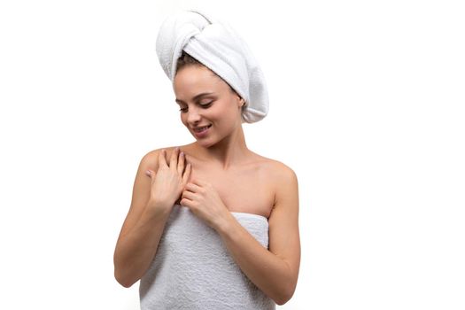 a young woman after a shower gently touches her body with her hands.