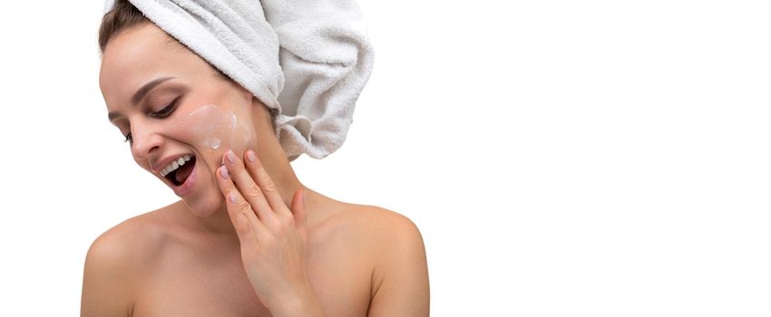 cheerful woman after shower applying cream on her face skin care cosmetic procedures.