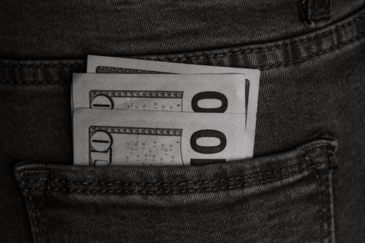 Banknotes close up, money in a jeans pocket. Dollars stick out of the jeans pocket, finance and currency concept. Concept of saving or spending money