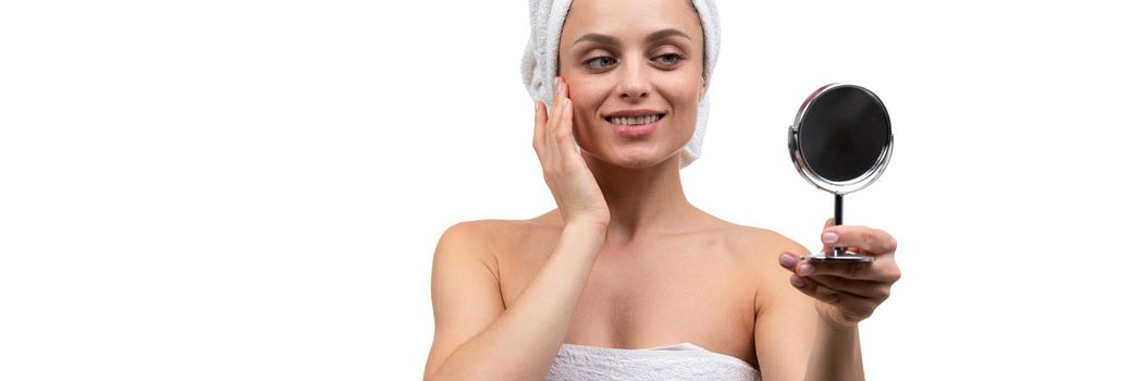 middle aged woman after shower with mirror in hands, spa concept skin care.