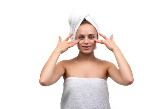 young woman after a shower touches her face with her fingers.
