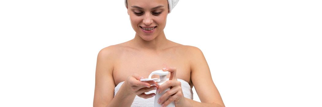 a woman after a shower applies a mousse for facial care on a cosmetic cotton pad.