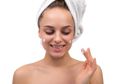 middle-aged woman with a smile on her face after cosmetic procedures apply cream on her face