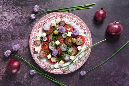 cherry tomato salad with purple onion rings dressed with balsamic dressing and olive oil with feta cheese and olives on a dark purple background, step by step recipe,flat lay