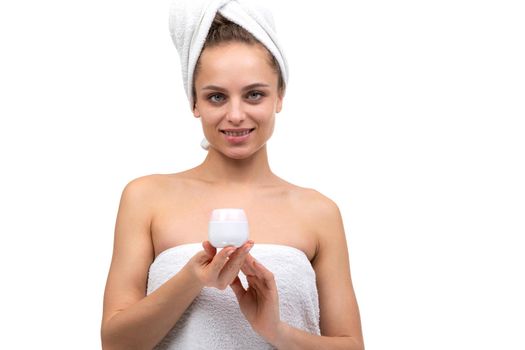 beautiful middle-aged woman holding a jar of cream after a shower