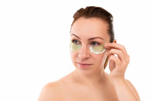 young woman on with cosmetic patches under her eyes.