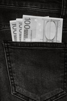 Banknotes, money in a jeans pocket, close up. Money stick out of the jeans pocket, finance and currency concept. Concept of rich people, saving or spending money.