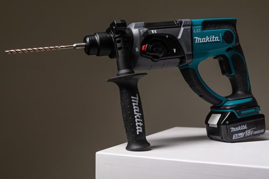 Photo shot of Makita drill instrument tool for drilling holes isolated on background with copy space. Repair and construction concept.