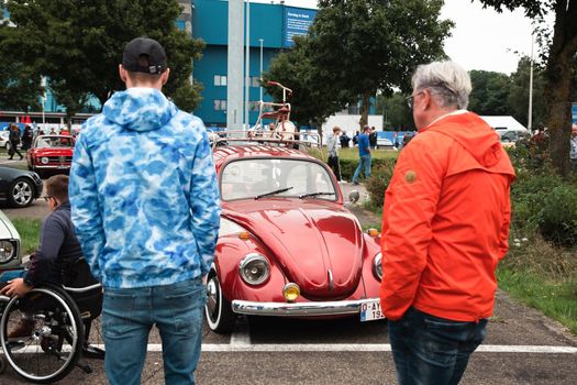 Genk, BELGIUM, August 18, 2021: classic summer meet of oldtimer at The Luminus Arena Genk, red and grey volkswagen beetle, High quality photo