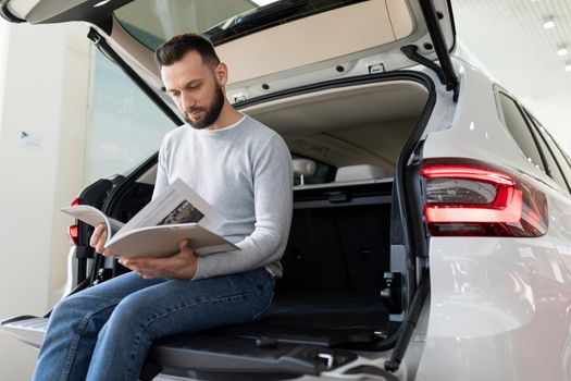 middle-aged man examines the offer of an insurance company for car insurance.