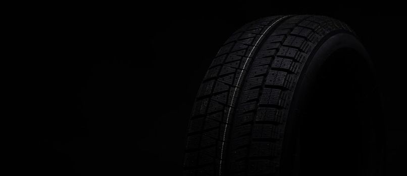 image photograph of a black tire on a black background.