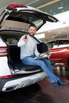 a satisfied customer demonstrates the keys of a new SUV.