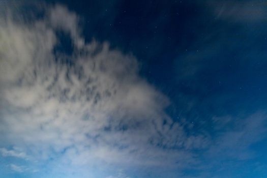 Dark blue sky on long exposure with moving clouds at night 