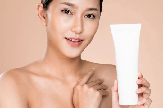 Closeup ardent woman smiling holding mockup product for advertising text place, light grey background. Concept of healthcare for skin, beauty care product for advertising.