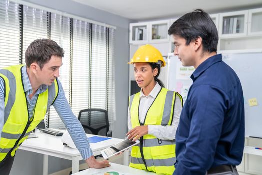 Engineers and competent employer discussing plans and blueprints together with tablet in the office. Concept of team contribution of ideas for engineering project.