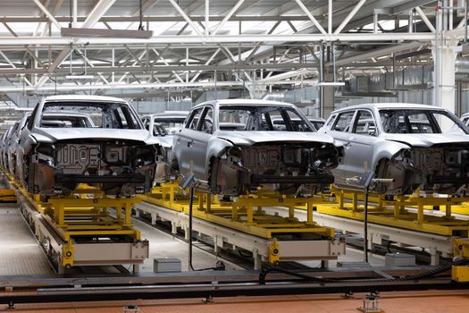 Photo of automobile production line. Welding car body. Modern car assembly plant. Auto industry. Interior of a high-tech factory.