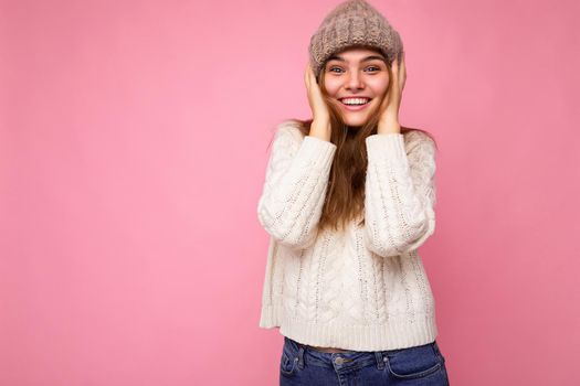 Attractive smiling happy young brunet woman standing isolated over colorful background wall wearing everyday stylish outfit showing facial emotions looking at camera. Copy space