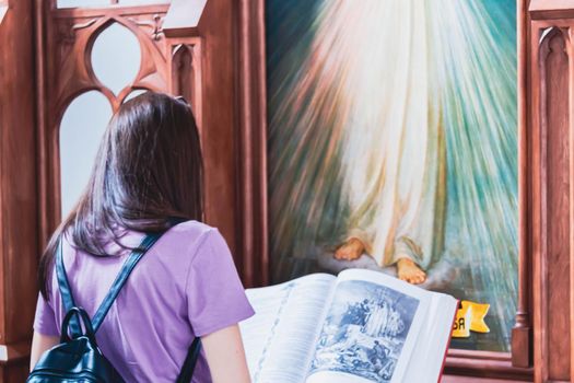 The girl prays in the church. Church parish. Christian faith. Reading in front of the icon. Prayer time.