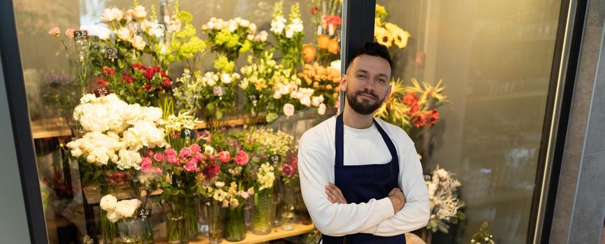 the owner of the flower shop next to the refrigerator with beautiful bouquets.