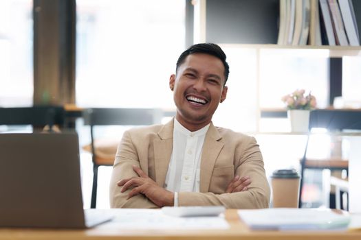 Asian Businessman smiling and working to analyze technical price graph and indicator. finance concept.