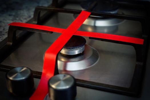 Gas stove with red ribbon criss-cross, does not work at home, in the kitchen. Unavailability of natural gas. The concept of the cost of propane gas, expensive price, war, EU sanctions.