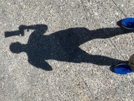 Shadow of photographer on the ground with telescopic lens , background.