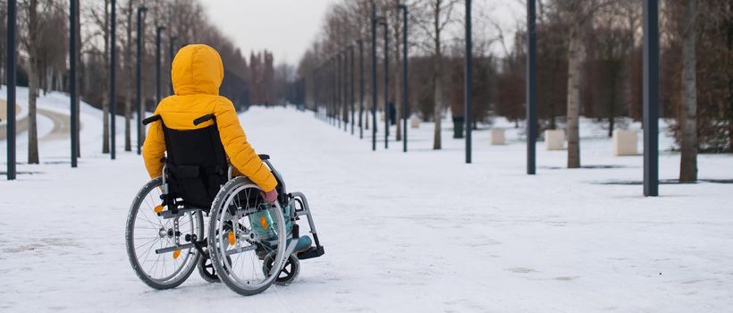 Woman in wheelchair relaxing in winter park