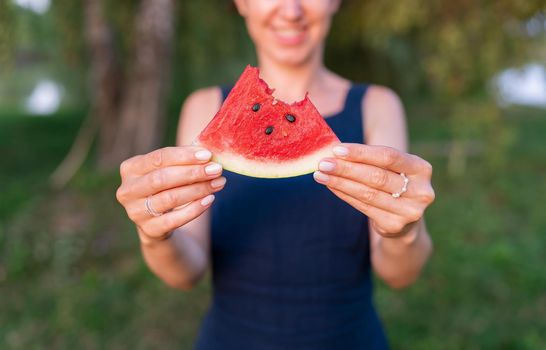 Portrait of a happy young woman holding a slice of watermelon and smiling. Summer, vacation