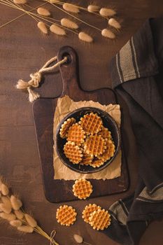 Waffer cookies on ceramic bowl on rustic background.