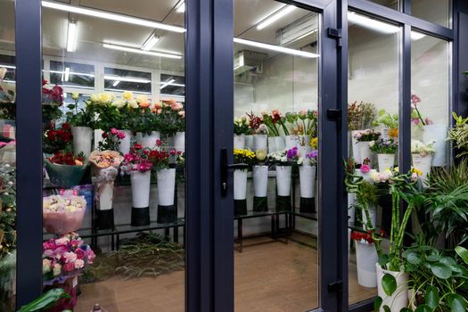 showcase of a florist shop selling natural flowers with bouquets in the refrigerator In vases
