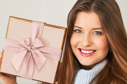 Winter holidays, present and Merry Christmas concept, happy woman smiling and holding wrapped gift box, close-up portrait