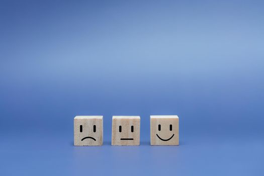 Emotion face on wooden cube.  Ranking for service customer review and feedback concept