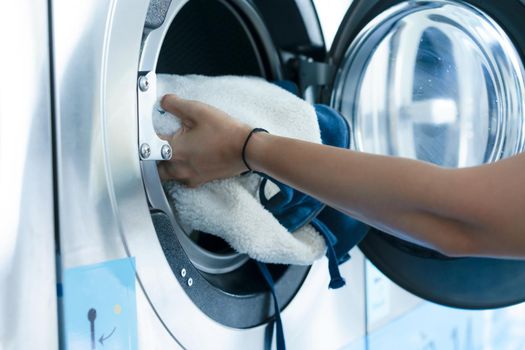 Hand of woman laundry by the washing machine