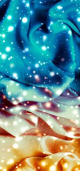 Winter fashion, shiny fabric and glamour style concept - Magic holiday blue and gold soft silk flatlay background texture with glowing snow, luxury beauty abstract backdrop