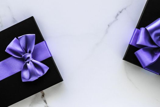 Wedding present, shop sale promotion and anniversary celebration concept - Luxury holiday gifts with lavender silk ribbon and bow on marble background