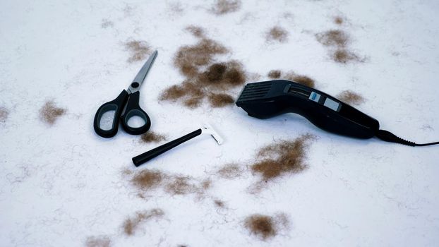 close up of Barber tools and a lot of cut hair from the body, on white background. tools for depilation, hair removal, Men's haircut. clipper, electric razor, trimer, scissors. High quality photo