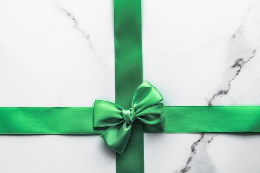 Decorative, birthday and art branding concept - Green silk ribbon and bow on marble background, St Patricks day present or Christmas glamour gift decor for luxury digital brand, holiday flatlay design