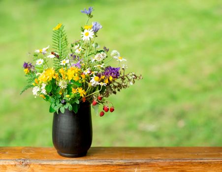 bouquet of wild flowers on a wooden background