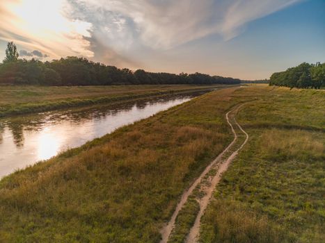 Beautiful colorful landscape of long field between forest and long Odra river