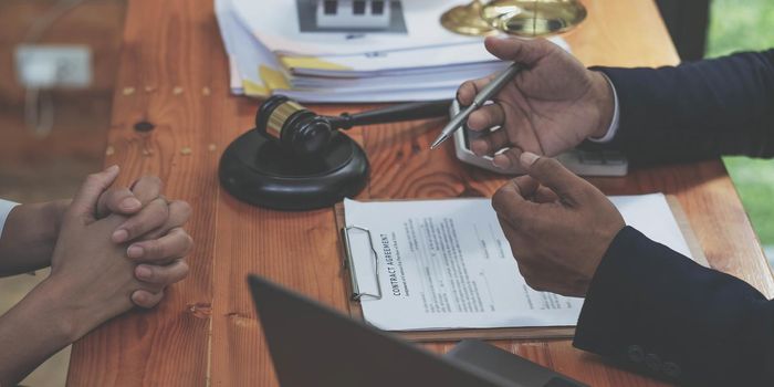 Business people negotiating a contract. man hands working with documents at desk and signing contract. Closeup view..