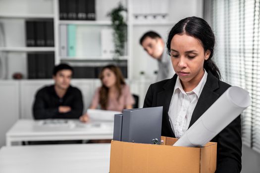 Depressed and disappointed employee packing her belongings after being fired for not being competent. Gossiped by her colleagues behind his back. Layoff due to economic depression.